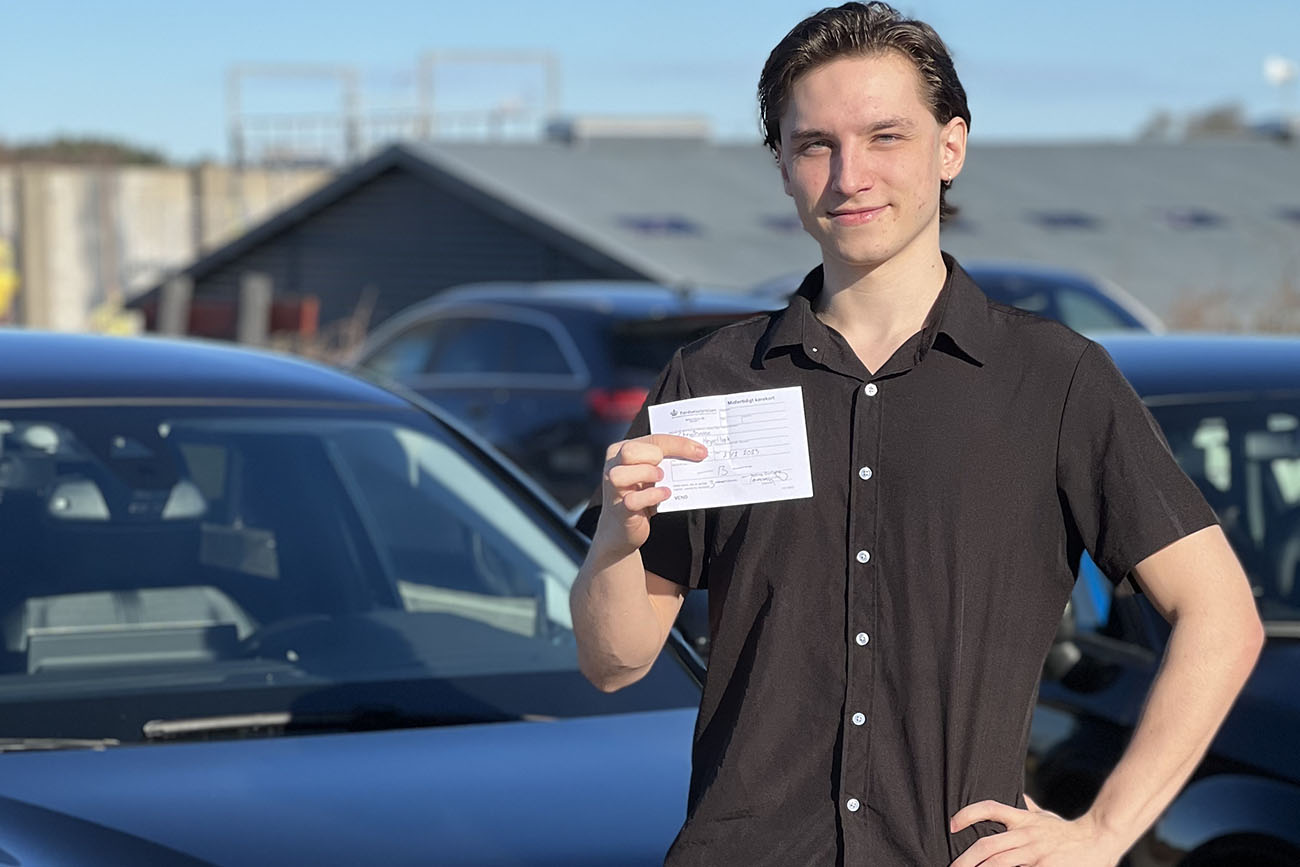 Dreng har bestået køreprøven og holder sit nye kørekort
